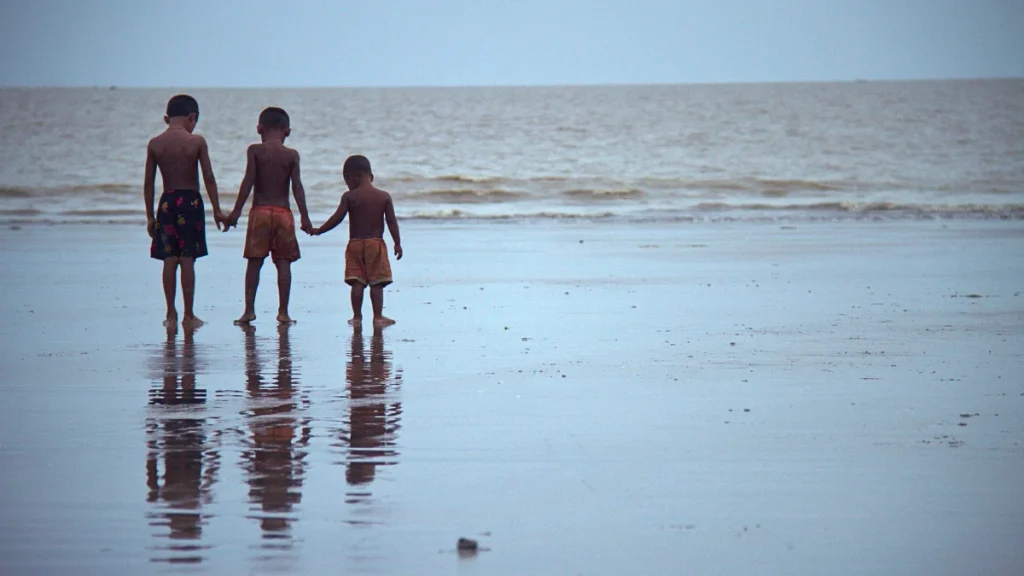 সমুদ্রপাড়ে দাঁড়ানো শিশুরা—উপকূলের ভাঙনের সঙ্গে লড়াই করা ভবিষ্যৎ প্রজন্মের প্রতিচ্ছবি।